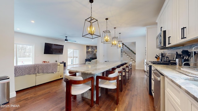 dining area with dark hardwood / wood-style floors and ceiling fan