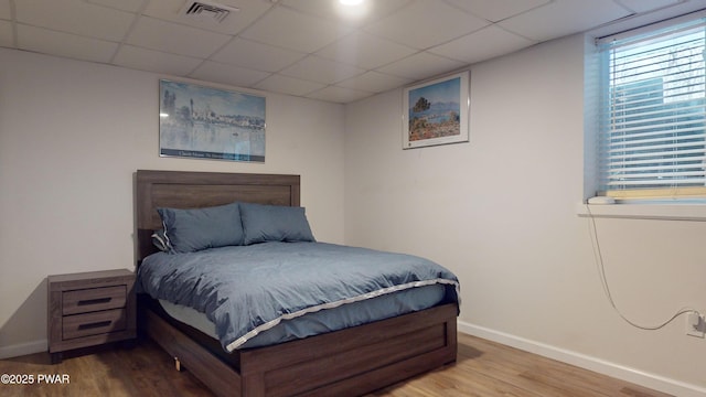 bedroom featuring a paneled ceiling and hardwood / wood-style floors