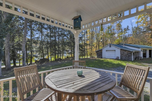 517 Sherman Rd, Susquehanna, PA 18847 - deck featuring a lawn, an outdoor structure, view of scattered trees, outdoor dining space, and a garage