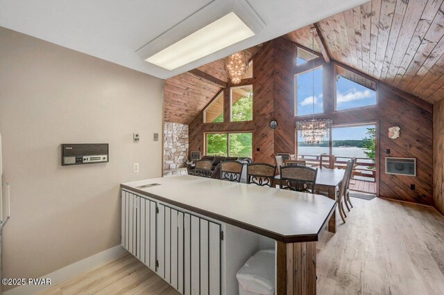 518 Lakeview Dr E, Lake Ariel, PA 18436 - dining space with a chandelier, wooden ceiling, light wood-style flooring, wood walls, and high vaulted ceiling