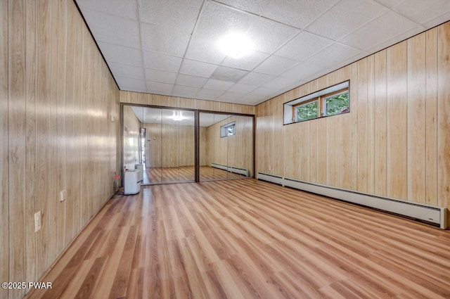 518 Lakeview Dr E, Lake Ariel, PA 18436 - below grade area featuring a baseboard radiator, wood finished floors, wood walls, and a paneled ceiling