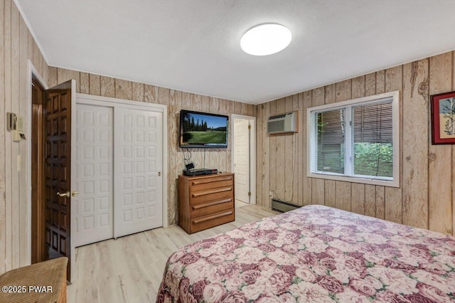 518 Lakeview Dr E, Lake Ariel, PA 18436 - bedroom featuring a wall mounted AC, light wood-style flooring, a closet, baseboard heating, and wood walls