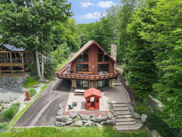 518 Lakeview Dr E, Lake Ariel, PA 18436 - rear view of house featuring a chimney, stone siding, and a view of trees
