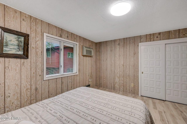 518 Lakeview Dr E, Lake Ariel, PA 18436 - bedroom with wood walls, a wall mounted AC, wood finished floors, and a closet