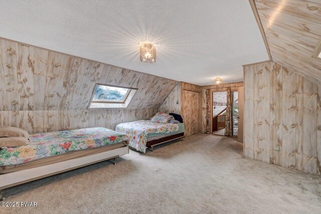 518 Lakeview Dr E, Lake Ariel, PA 18436 - carpeted bedroom with wooden walls, a skylight, lofted ceiling, and a textured ceiling