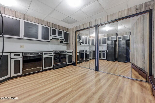518 Lakeview Dr E, Lake Ariel, PA 18436 - kitchen featuring black appliances, light wood-style flooring, range hood, a baseboard radiator, and glass insert cabinets