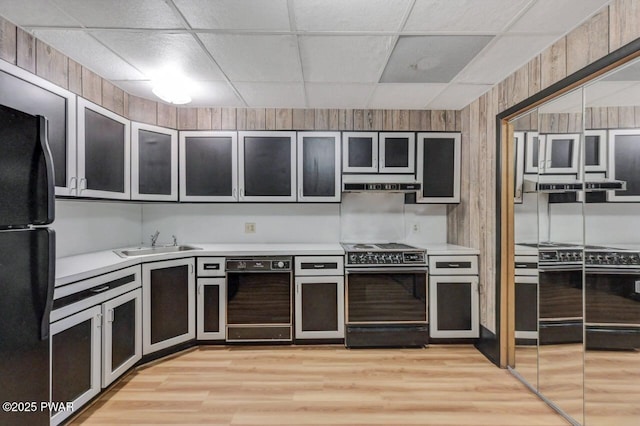 518 Lakeview Dr E, Lake Ariel, PA 18436 - kitchen with black appliances, under cabinet range hood, light countertops, a drop ceiling, and light wood-style floors