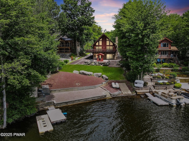 518 Lakeview Dr E, Lake Ariel, PA 18436 - back of property at dusk with stairs, a lawn, and a deck with water view