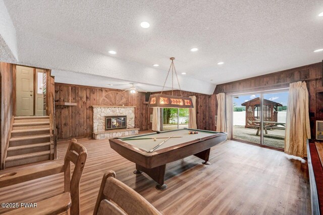 518 Lakeview Dr E, Lake Ariel, PA 18436 - game room with wood walls, a textured ceiling, wood finished floors, billiards table, and a stone fireplace