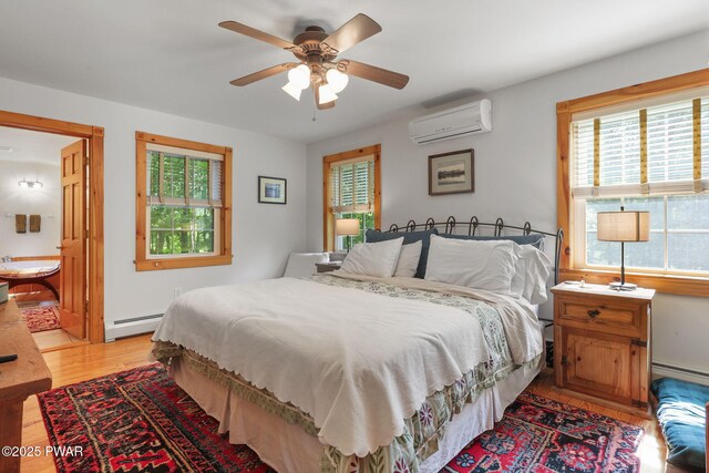 58 Rude Rd, Waymart, PA 18472 - bedroom featuring a wall unit AC, baseboard heating, light wood-style flooring, a baseboard heating unit, and ceiling fan