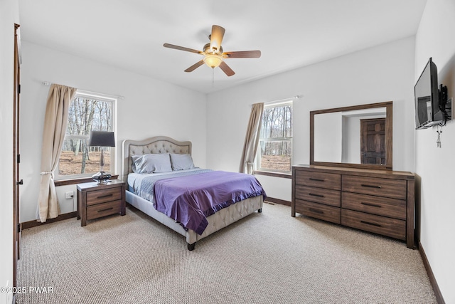 bedroom with baseboards, light carpet, and a ceiling fan