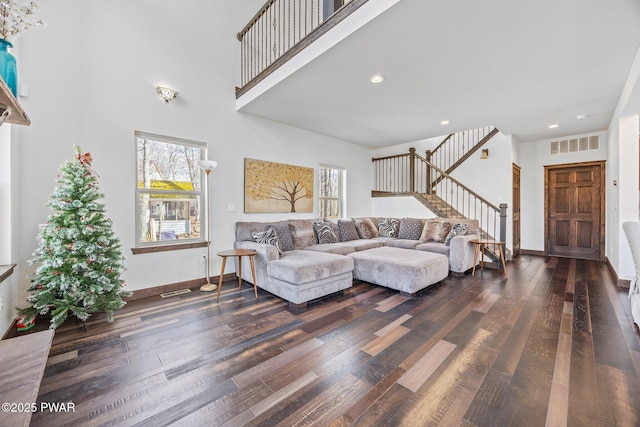 living area with plenty of natural light, stairs, wood finished floors, and visible vents