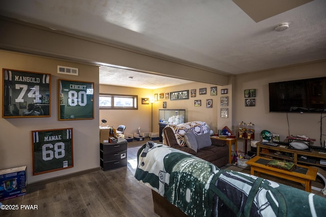 bedroom with dark wood-style floors and visible vents