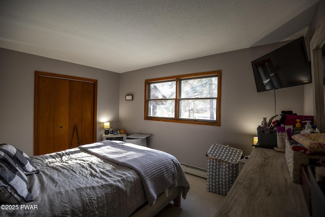 bedroom featuring a baseboard heating unit, carpet, a closet, and a textured ceiling