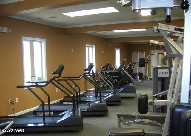 workout area with baseboards and ornamental molding