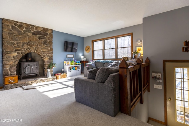 living room with a wood stove and carpet