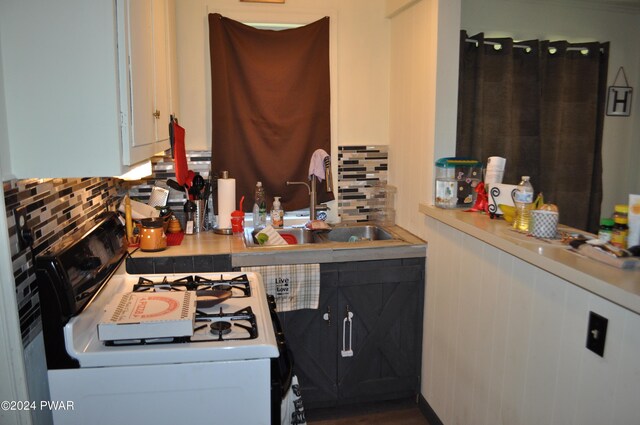 kitchen with white cabinetry, white gas range, decorative backsplash, and sink