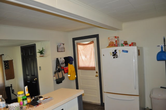 kitchen with crown molding and white fridge