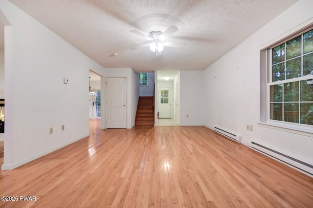 102 Eagle Rock Rd, Lackawaxen, PA 18435 - unfurnished living room featuring a baseboard heating unit, light wood-type flooring, stairs, ceiling fan, and a textured ceiling