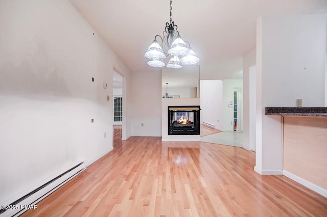 102 Eagle Rock Rd, Lackawaxen, PA 18435 - unfurnished living room featuring baseboard heating, wood finished floors, a chandelier, and a multi sided fireplace