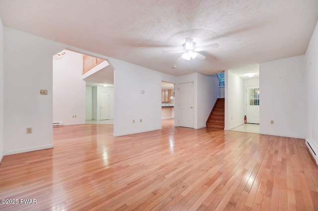 102 Eagle Rock Rd, Lackawaxen, PA 18435 - unfurnished living room featuring a ceiling fan, light wood-style floors, stairs, a baseboard radiator, and a textured ceiling