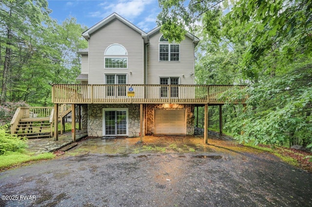 102 Eagle Rock Rd, Lackawaxen, PA 18435 - view of front facade with a deck, stairway, an attached garage, asphalt driveway, and stone siding