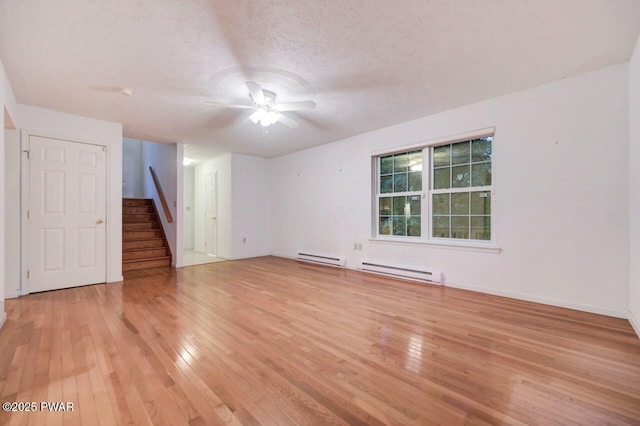 102 Eagle Rock Rd, Lackawaxen, PA 18435 - spare room featuring light wood-type flooring, a ceiling fan, stairway, baseboard heating, and a textured ceiling