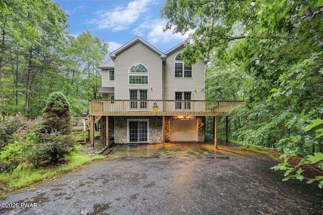 102 Eagle Rock Rd, Lackawaxen, PA 18435 - view of front of house featuring asphalt driveway, a wooden deck, stone siding, an attached garage, and stairs
