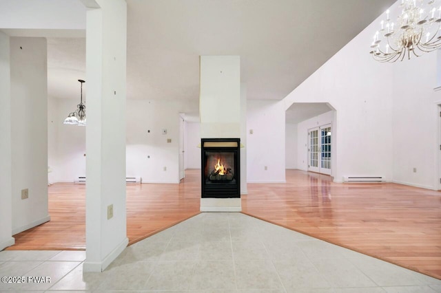 102 Eagle Rock Rd, Lackawaxen, PA 18435 - unfurnished living room with tile patterned flooring, arched walkways, a baseboard radiator, a chandelier, and a multi sided fireplace