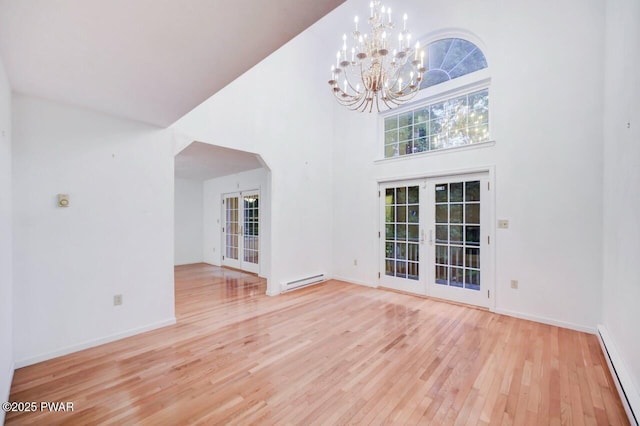 102 Eagle Rock Rd, Lackawaxen, PA 18435 - unfurnished living room featuring french doors, a baseboard radiator, wood finished floors, a baseboard heating unit, and a chandelier