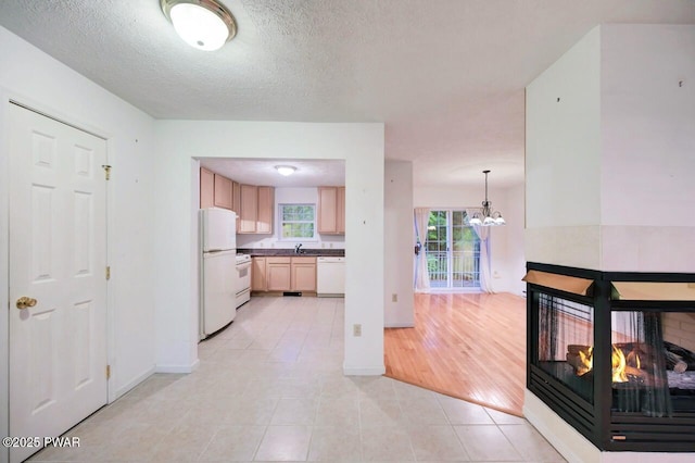 102 Eagle Rock Rd, Lackawaxen, PA 18435 - kitchen featuring white appliances, light tile patterned flooring, a chandelier, dark countertops, and a textured ceiling