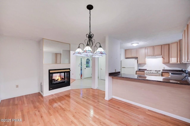 102 Eagle Rock Rd, Lackawaxen, PA 18435 - kitchen featuring white appliances, under cabinet range hood, light wood-type flooring, hanging light fixtures, and dark stone countertops