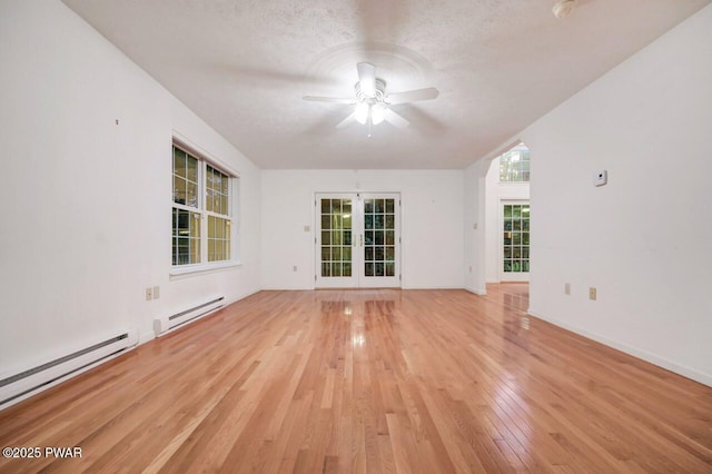 102 Eagle Rock Rd, Lackawaxen, PA 18435 - unfurnished room with a baseboard radiator, ceiling fan, light wood-type flooring, french doors, and a textured ceiling