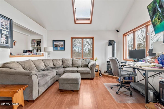 home office with lofted ceiling with skylight, a wealth of natural light, and light hardwood / wood-style floors