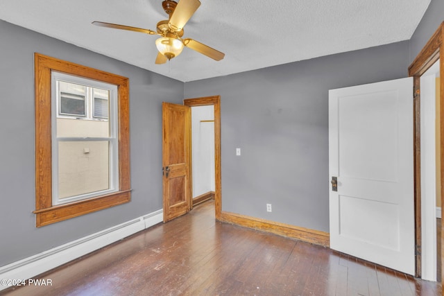 unfurnished room featuring a textured ceiling, dark wood-type flooring, ceiling fan, and a baseboard heating unit