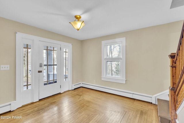 entrance foyer featuring light parquet floors and a baseboard heating unit