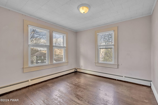 spare room featuring a wealth of natural light, hardwood / wood-style floors, and ornamental molding