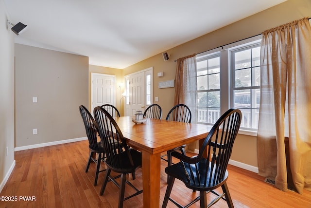 dining area featuring light wood-style floors and baseboards