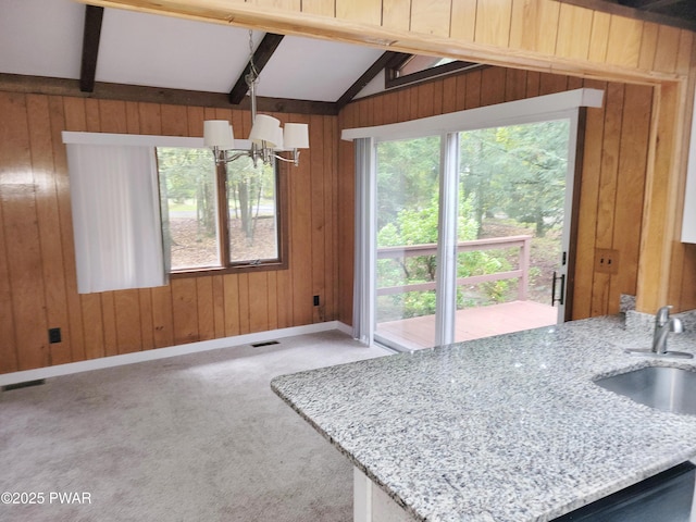 803 Lariat Ct, Hawley, PA 18428 - kitchen with a chandelier, wood walls, a sink, light stone countertops, and baseboards