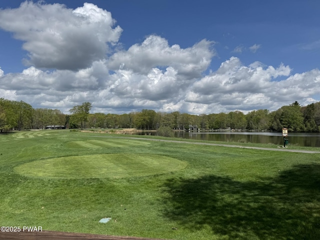 surrounding community featuring a water view, view of golf course, and a lawn