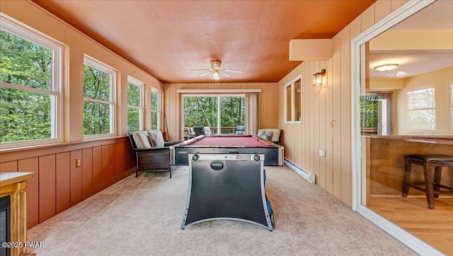 recreation room featuring carpet floors, a ceiling fan, wood walls, a baseboard radiator, and billiards