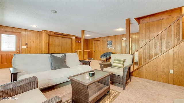 living room with light colored carpet, wooden walls, and a textured ceiling