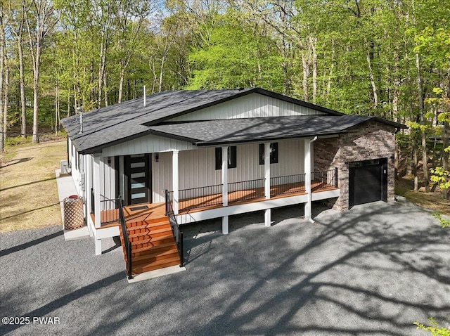 517 Maple Ridge Dr, Lords Valley, PA 18428 - view of front of home with a shingled roof, covered porch, and a view of trees
