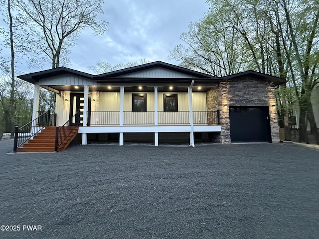 517 Maple Ridge Dr, Lords Valley, PA 18428 - view of front facade featuring a porch, stone siding, a garage, and stairs