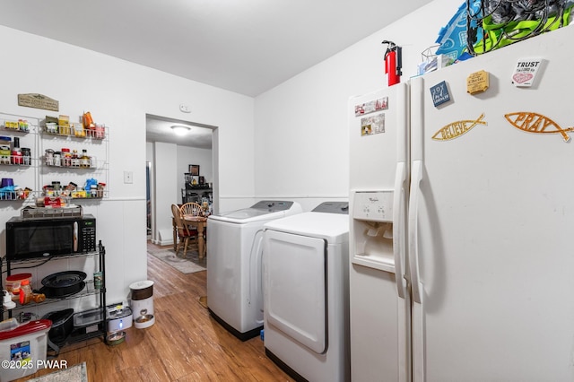 laundry room with light wood-type flooring and washing machine and dryer