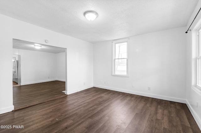 unfurnished room featuring dark hardwood / wood-style floors and a textured ceiling