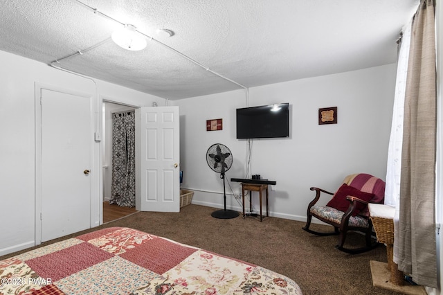 bedroom featuring a textured ceiling and dark colored carpet