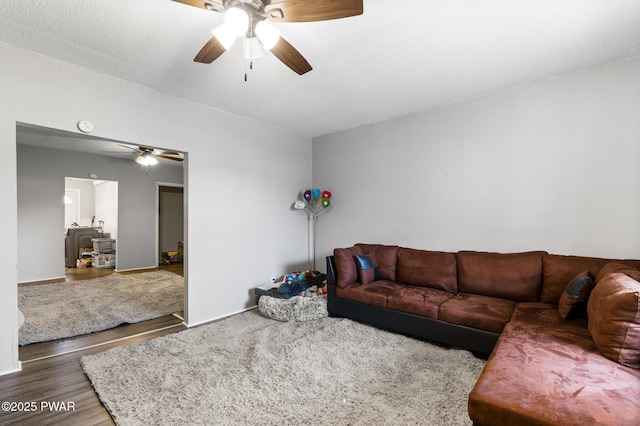 living room with wood-type flooring, a textured ceiling, and ceiling fan