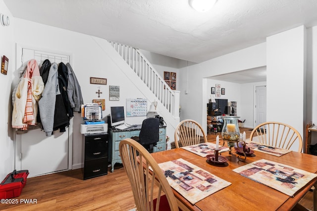 dining room featuring light hardwood / wood-style floors and a textured ceiling