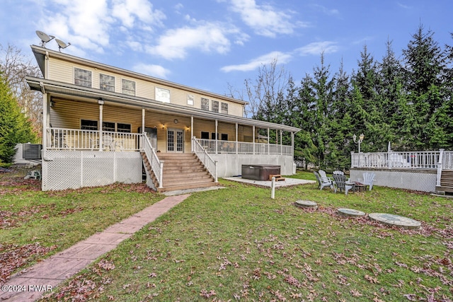 exterior space featuring a wooden deck, a front lawn, central AC unit, and a hot tub